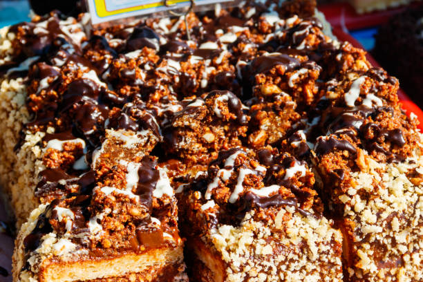 istock Sliced snickers cake close-up. Chocolate cake with peanuts on a tray 1061438516