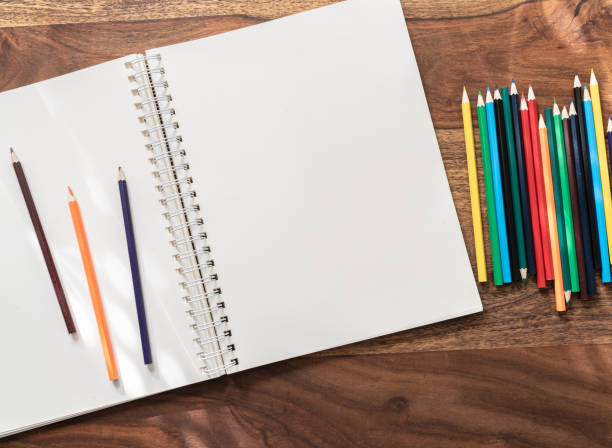 istock empty open sketchbook and colored pencils on wooden table 1061438676