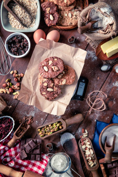 biscotti al cioccolato e noci sulla bilancia digitale del peso alimentare della cucina. - biscotti cookie chocolate pistachio foto e immagini stock