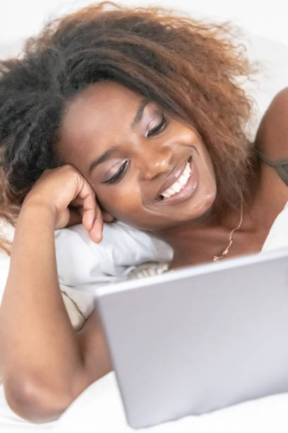 istock Smiling Beautiful black young woman looking at her digital tablet 1061444246