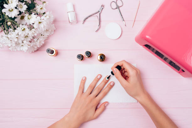 istock Flatlay of female hands apply covering shellac during manicure procedure 1061447814