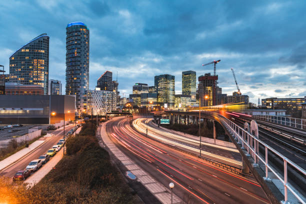 stadtblick mit wolkenkratzern, verschwommene zug und ampel wanderwege - london england canary wharf skyline cityscape stock-fotos und bilder