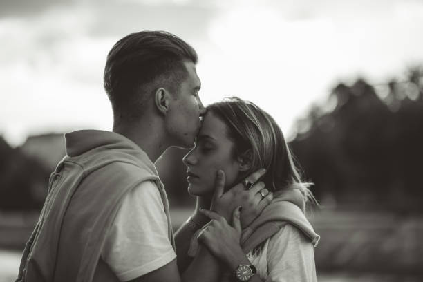 istock Young couple kissing by the river 1061461376