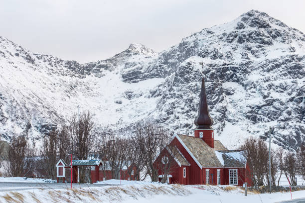 flakstad igreja, uma bela igreja de madeira vermelha nas montanhas nevadas da ilha vestvågøy em lofoten, nordland, noruega - vestvagoy - fotografias e filmes do acervo