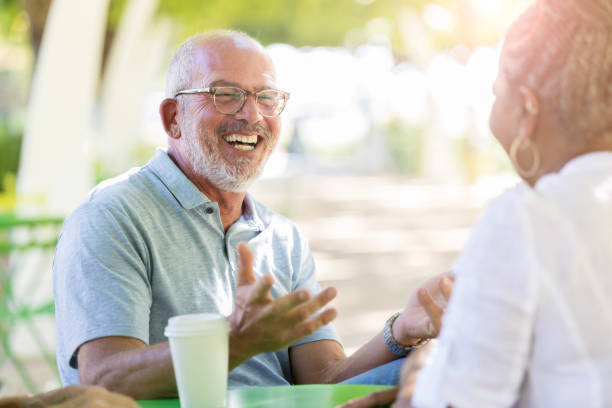 istock Senior friends laugh while drinking coffee outdoors 1061473802