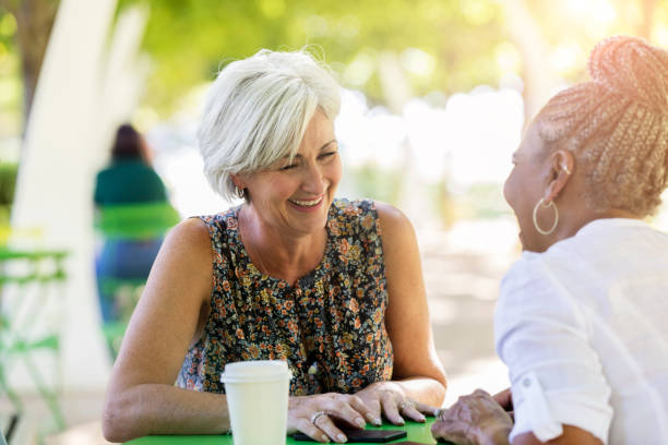 istock Two beautiful female teachers laugh while outside on lunch break 1061473810