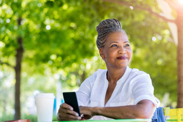 istock Senior woman day dreams while sitting in nature park 1061473818