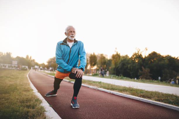 istock Senior man stretching outdoors on a running track before running 1061477356
