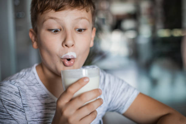 boy enjoying a glass of yogurt - milk mustache imagens e fotografias de stock