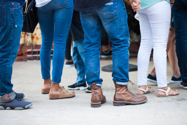 Crowd of unrecognizable people wait in line in a urban setting/queue of people stock photo