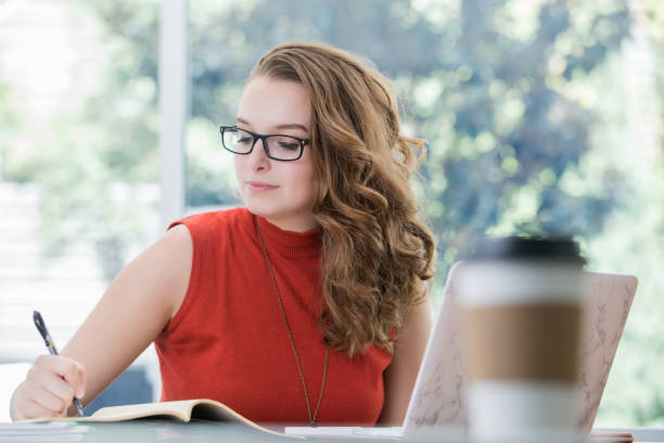istock Young professional woman working in collaborative office space with laptop 1061495100