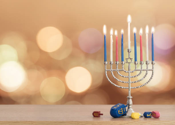 hanukkah fond fête juive avec la menorah (candélabre de judaïsme) brûlant des bougies et jouet jeu traditionnel dreidrel sur table en bois et flare de soleil automne bokeh - traditional culture flash photos et images de collection