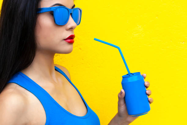 istock Woman in blue outfit drinking from blue can 1061501836