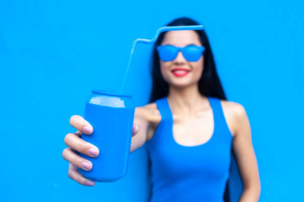 Woman in blue outfit offering blue drink