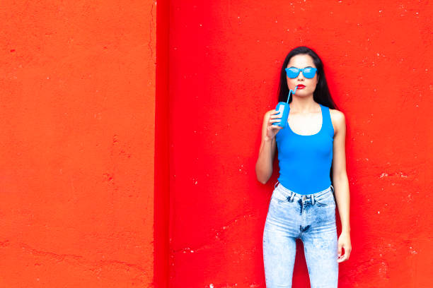 istock Woman drinking in front of red wall 1061501864