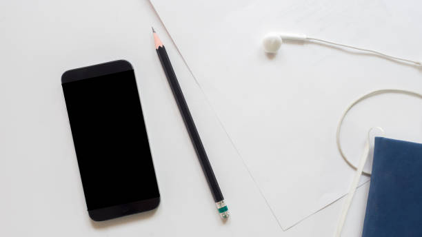 istock office desk table pencil with smart phone on white background 1061507090