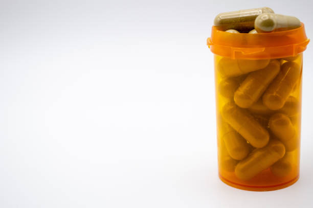istock Yellow medicine bottle with Maeng Da Kratom capsules 1061512568