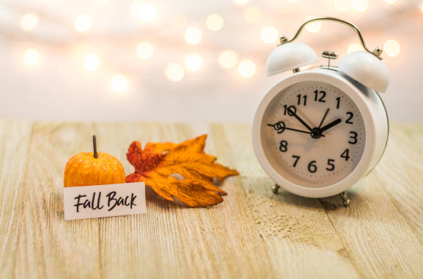 istock Fall Back Daylight Saving Time concept with white clock and autumn leaves 1061512820