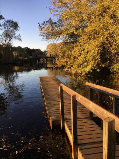 Dock Extending Over Water A beautiful fall afternoon at Minute Man National Historic Park in Concord, Massachusetts. concord massachusetts stock pictures, royalty-free photos & images