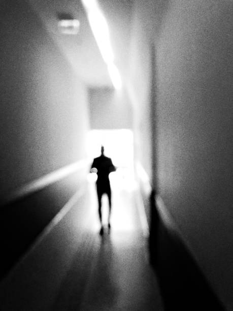 istock Monochrome defocused view of a man walking to light 1061518374