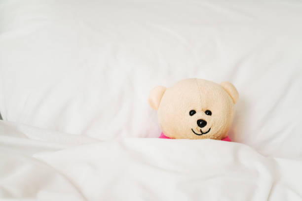 istock light brown smiling  bear doll on bed in bead room 1061518538