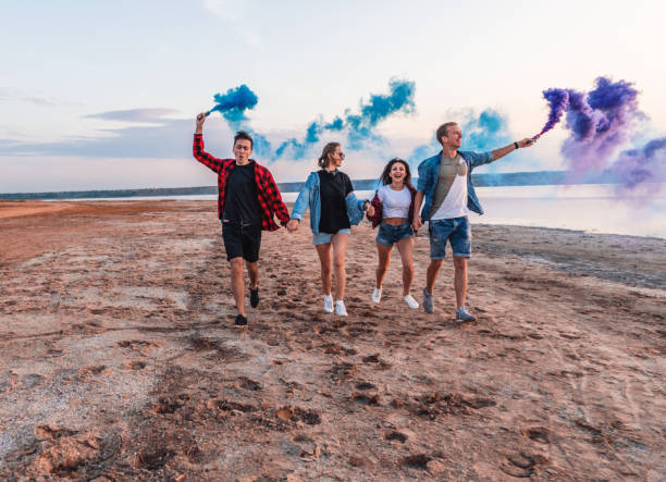 istock young friends running with hand flare or fusee 1061520302
