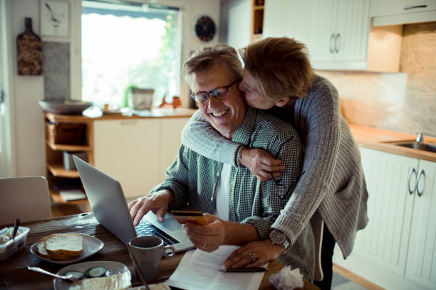 Online Shopping Close up of a mature couple doing online shopping in the morning swedish woman stock pictures, royalty-free photos & images