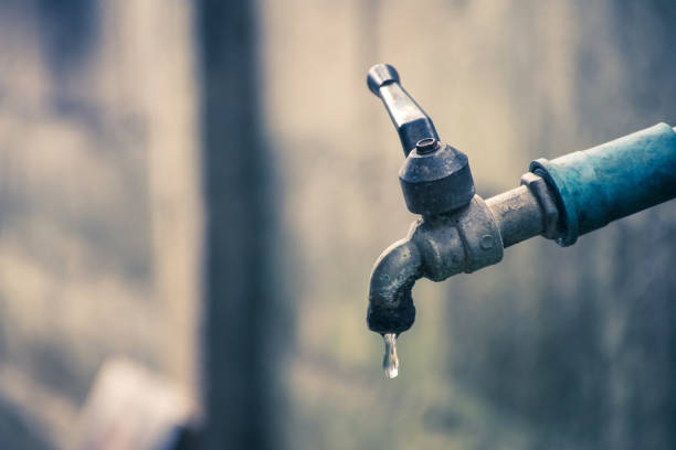 istock Old faucet with water leaking drop to the ground. 1061530236