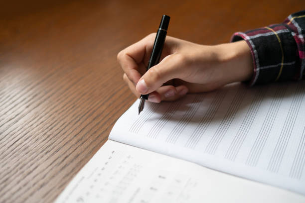 istock close up student hands write down music notes on class in school f 1061532868