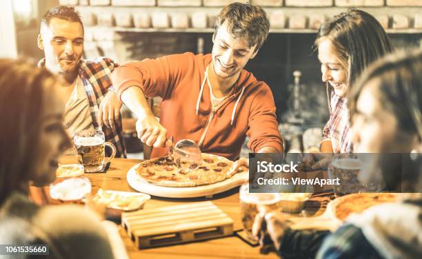 Young friends eating pizza at home on winter reunion - Friendship concept  with happy people enjoying time together and having fun drinking brew pints  Stock Photo - Alamy