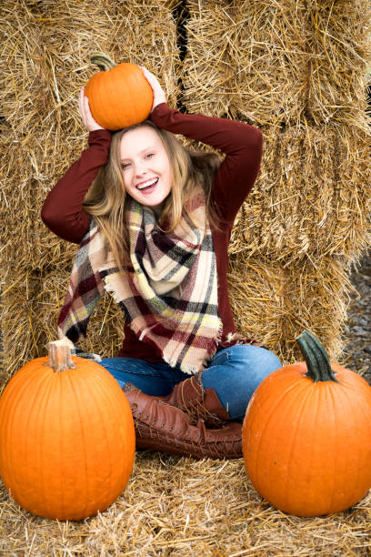 istock Teen with pumpkin in haystacks 1061535726