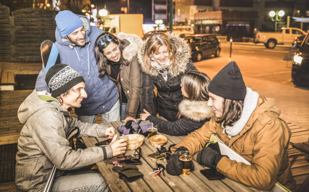 glückliche freunde trinken bier und essen chips am après-ski bar - freundschaft-konzept mit fröhlichen menschen, die spaß am chalet restaurant resort mit schnee-ausrüstung - hohe iso-image mit fokus auf mädchen - apres ski ski restaurant mountain stock-fotos und bilder