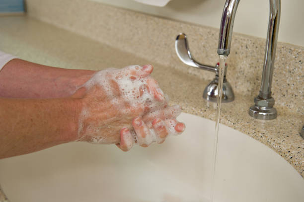 istock Washing Hands under running water in sink 1061556380