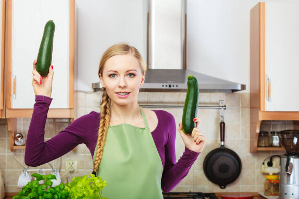 istock Woman in kitchen holds zucchini vegetable 1061559816