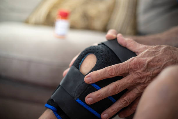 Pain A man with a painful knee. knee brace stock pictures, royalty-free photos & images