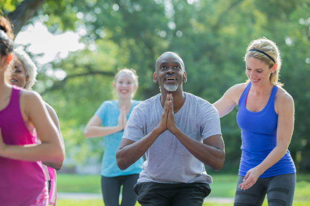 istock Yoga instructor helping senior African American man with pose during exercise class 1061563060