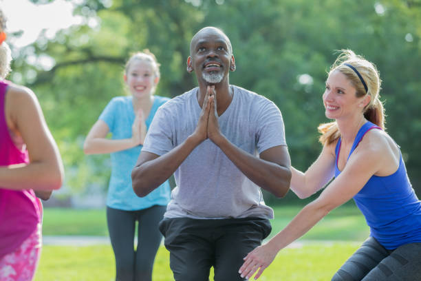 istock Happy senior man learning yoga pose in outdoor exercise class 1061563066