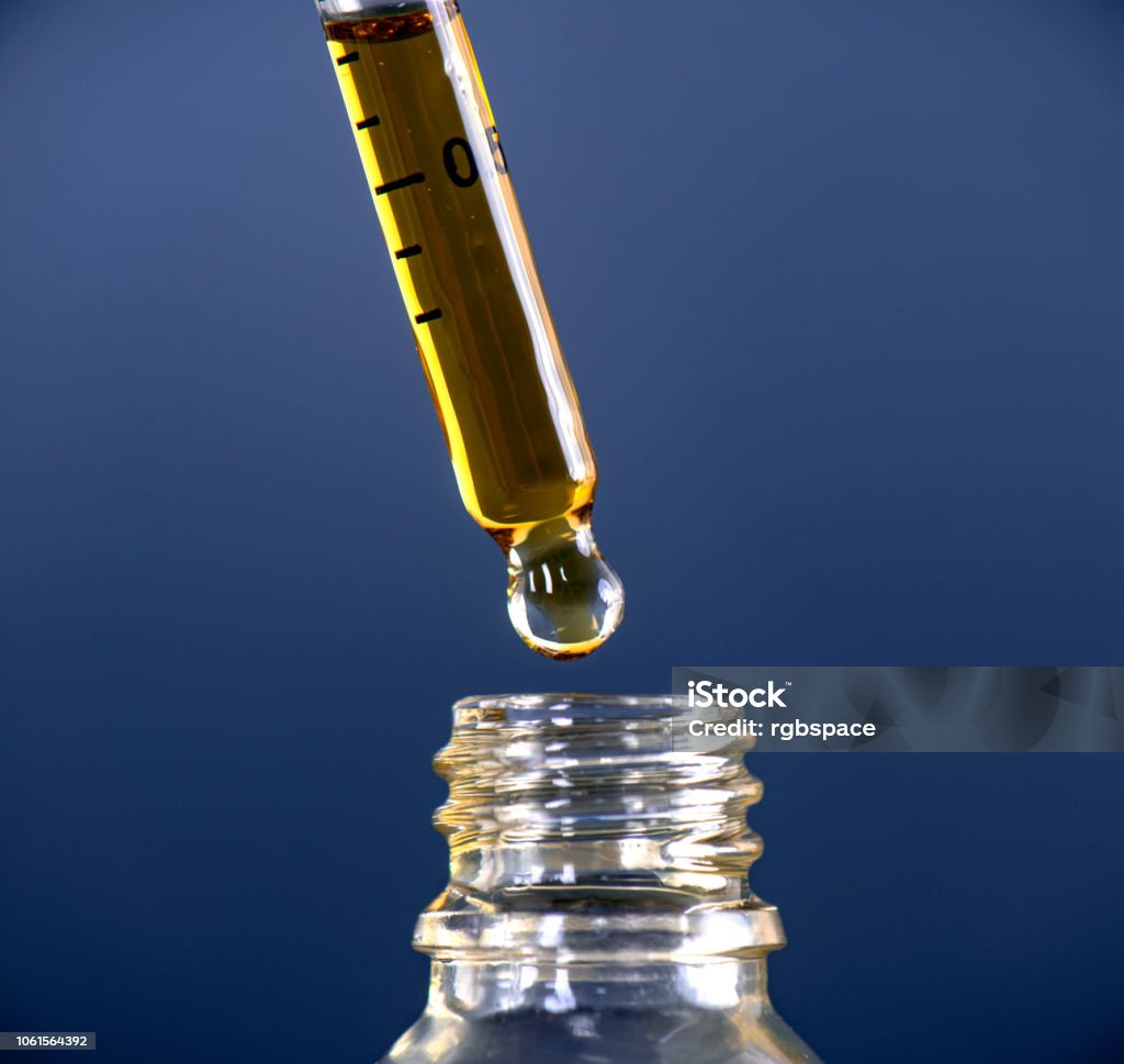 Cannabis CBD Oil extracted from the marijuana plant Macro detail of a dropper with Cannabis CBD Oil used for medical purposed Cannabinoid Stock Photo