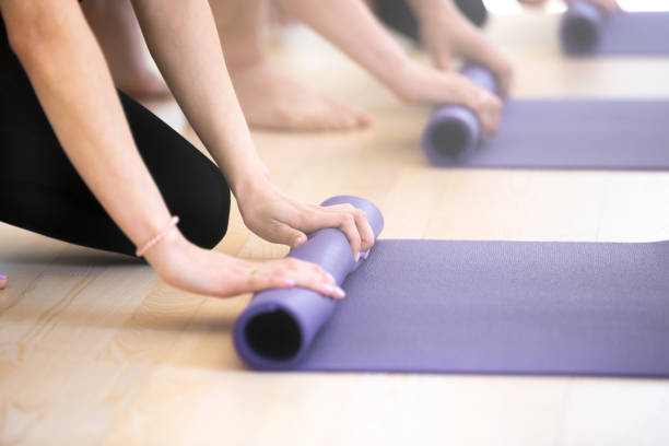 istock Close up people hands folding yoga mats 1061567820