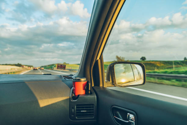 istock sunset reflection in car mirror on highway 1061579868