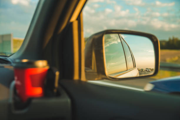 istock sunset reflection in car mirror on highway 1061579888