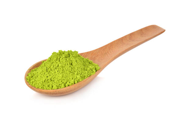 istock Powder green tea on wooden spoon isolated on white background 1061586594