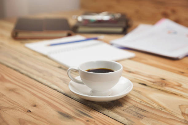 istock Closeup coffee cup on office desk with paper and analysis chart. 1061603932