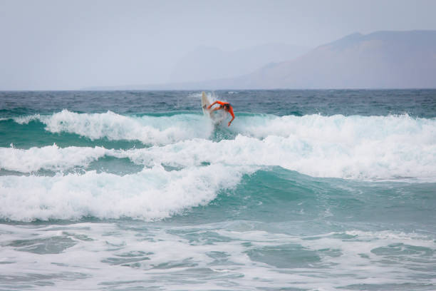 Surfer at Famara beach, Lanzarote Lanzarote, Spain - August 31st 2018: Surfer at Famara beach, La Caleta de Famara, Lanzarote, Canary Islands, Spain caleta de famara lanzarote stock pictures, royalty-free photos & images