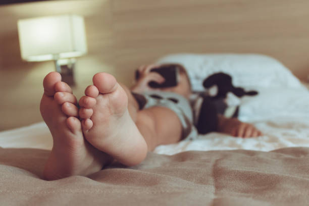 istock Close up of kid resting on the bed while using smart phone. 1061622862