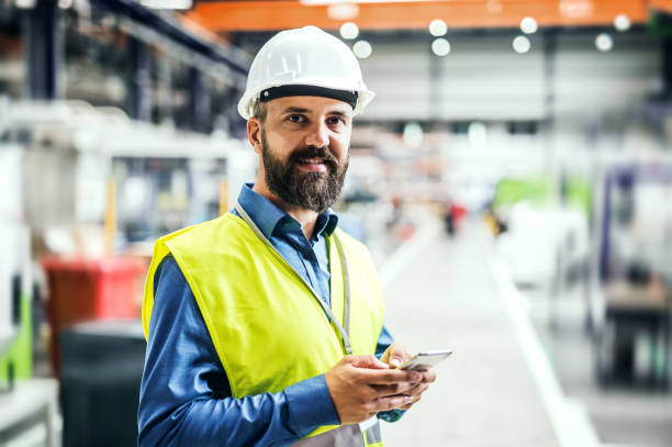 istock An industrial man engineer with name tag in a factory, using smartphone. 1061624874