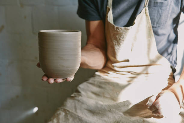 istock cropped image of professional potter in apron holding clay pot at workshop 1061626964