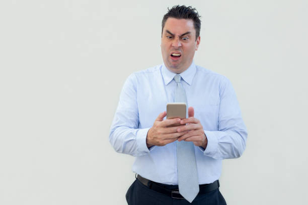 istock Annoyed emotional businessman using smartphone 1061627188