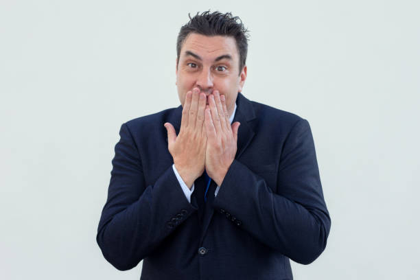 istock Positive embarrassed businessman covering mouth with hands 1061627308