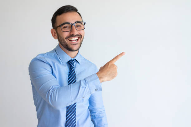 excited entrepreneur in glasses pointing aside and laughing - aside imagens e fotografias de stock